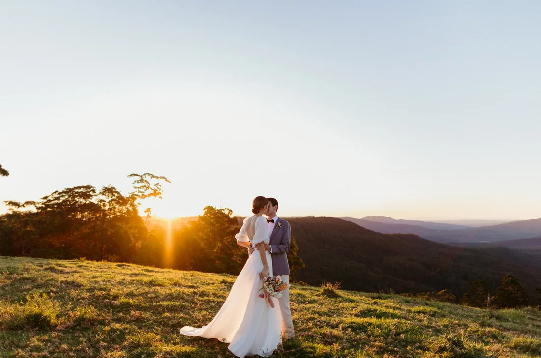 Two people on a ridge line at sunset